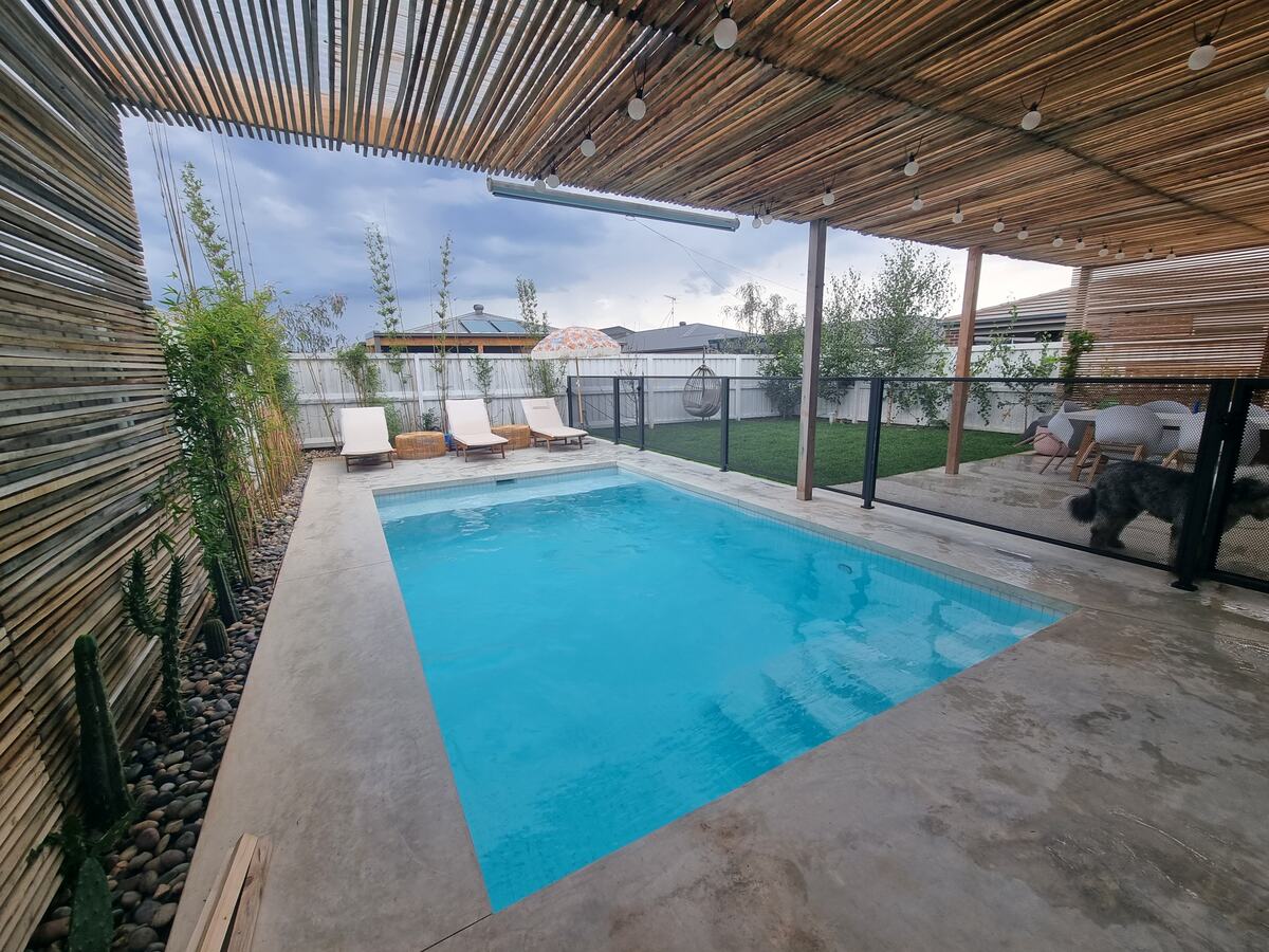 Pure Perf pool fencing in Textured Monument under a bamboo-roofed pool area, Victoria