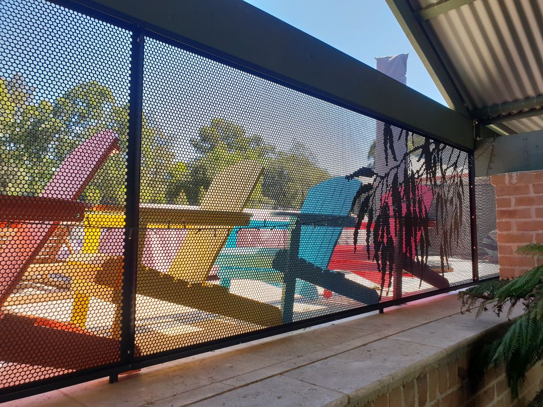 Gum leaf pattern pool fencing beside deck chairs, NSW
