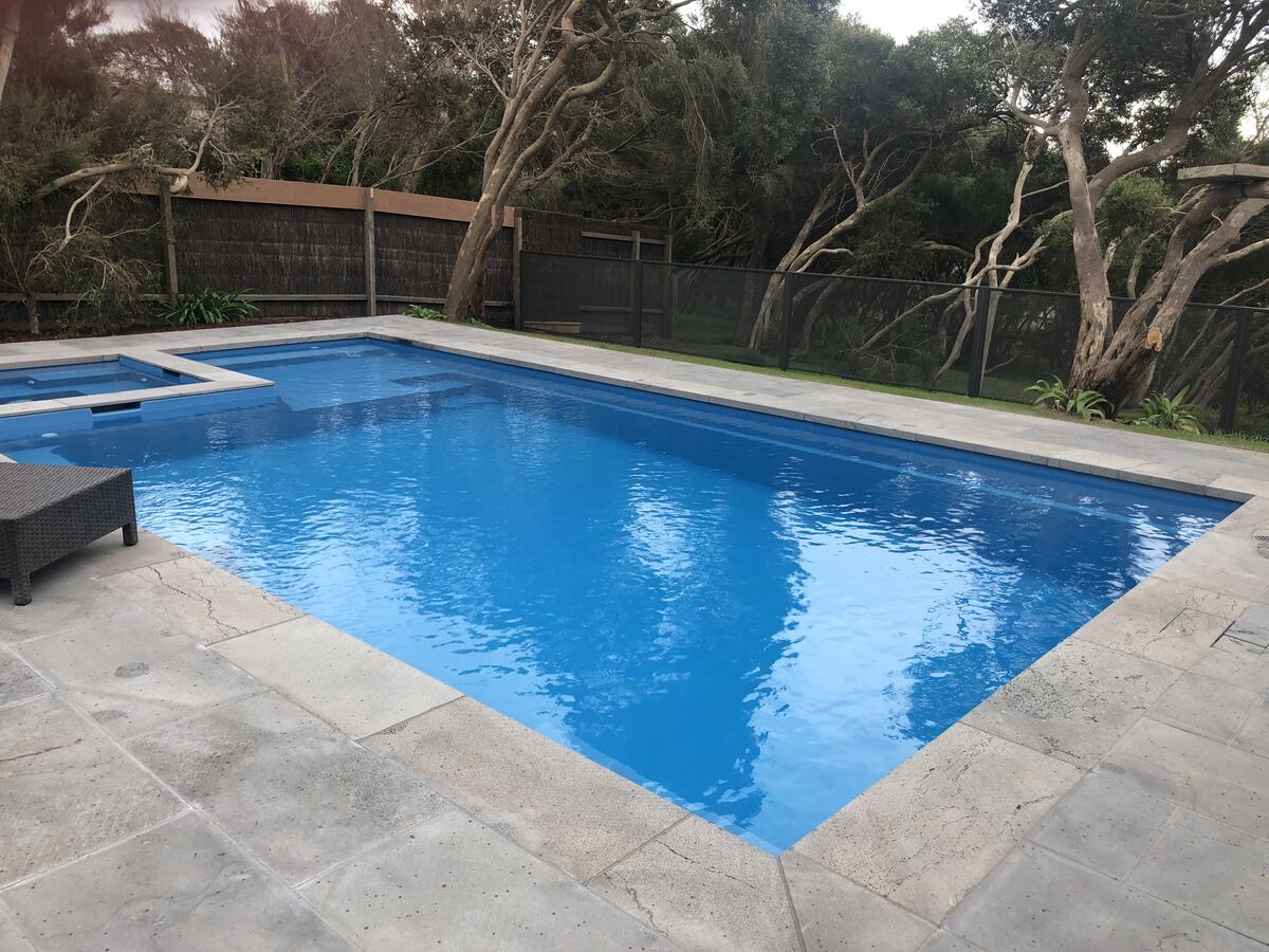Pure Perf pool fencing in Textured Black around a large blue swimming pool, Melbourne